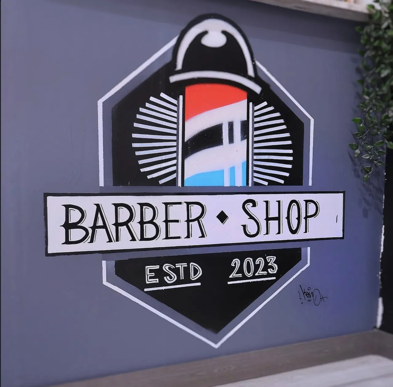 Logotipo Barber Shop Estd 2023 pintado en la pared de la barbería
